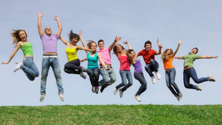 An image of young people in brightly coloured t-shirts jumping in the air
