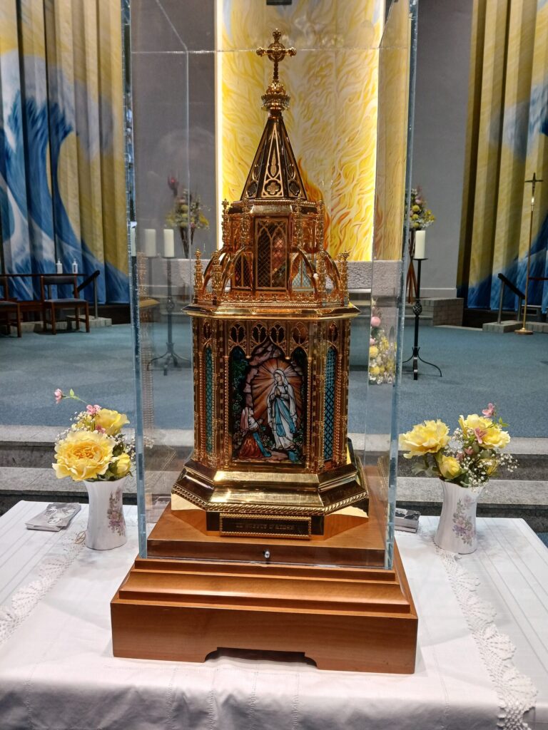 An intricate gold church model on the church alter