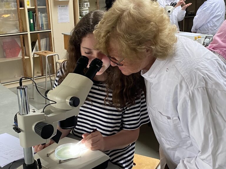 A woman and a girl looking through a microscope